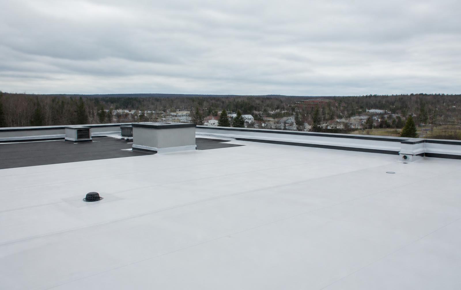 Toiture commerciale à membrane en cours d'installation au-dessus d'une ville québécoise